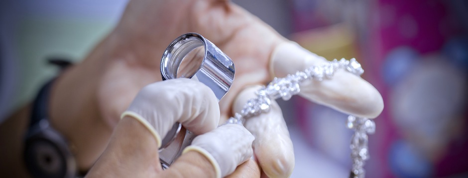 QC staff wearing rubber finger sack using loupe for detection of bracelet with diamond set